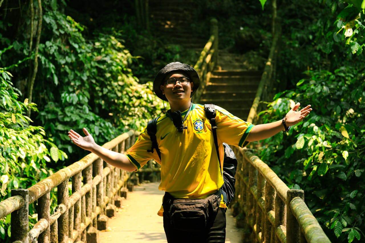 A man joyfully explores a vibrant forest pathway in Ninh Bình, Vietnam, surrounded by lush greenery.